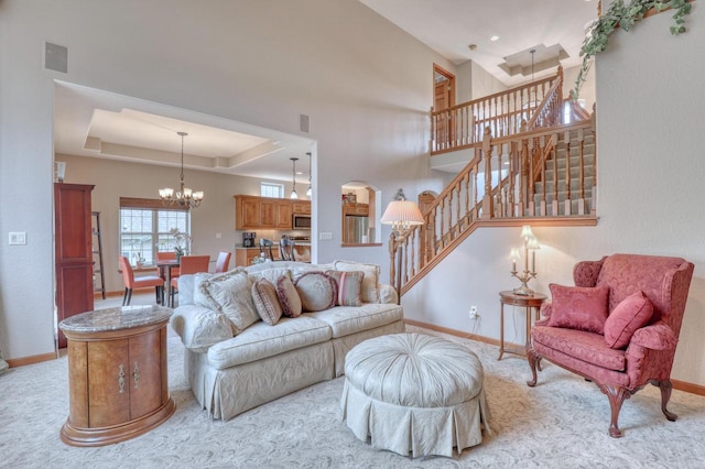 1826 Stonebridge Rd, Waukesha, WI 53188 - carpeted living room featuring baseboards, stairway, a chandelier, a tray ceiling, and arched walkways
