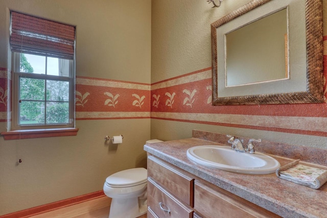 1826 Stonebridge Rd, Waukesha, WI 53188 - half bathroom featuring toilet, vanity, and a wainscoted wall