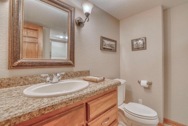 1826 Stonebridge Rd, Waukesha, WI 53188 - half bathroom featuring toilet, vanity, a textured wall, and a textured ceiling