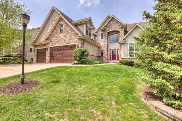 1826 Stonebridge Rd, Waukesha, WI 53188 - traditional-style home with stone siding, concrete driveway, an attached garage, and a front lawn