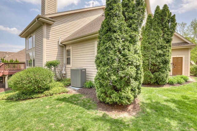 1826 Stonebridge Rd, Waukesha, WI 53188 - view of property exterior with cooling unit, a chimney, a yard, and a shingled roof