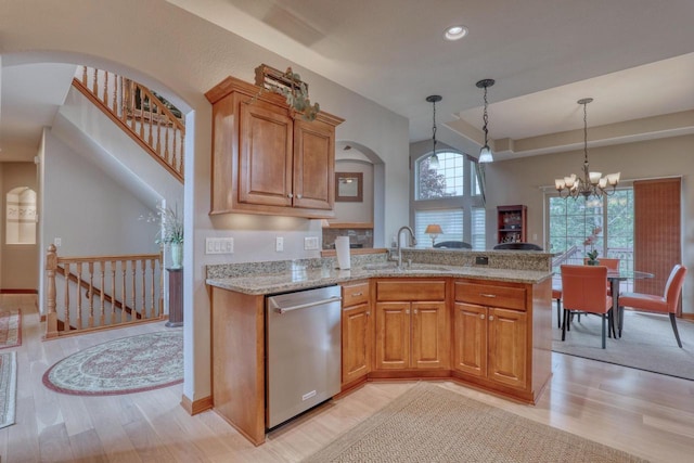 1826 Stonebridge Rd, Waukesha, WI 53188 - kitchen with stainless steel dishwasher, a sink, light wood finished floors, light stone countertops, and a peninsula