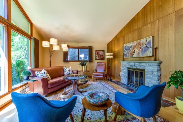 3914 Priscilla Ln, Madison, WI 53705 - living area with lofted ceiling, wooden walls, a fireplace, and wood finished floors