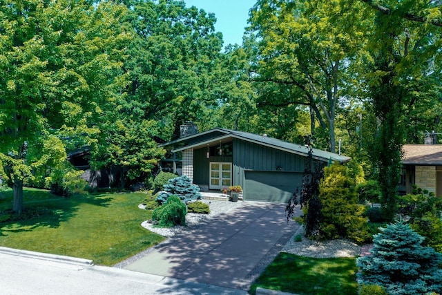 3914 Priscilla Ln, Madison, WI 53705 - mid-century modern home featuring a front lawn, an attached garage, concrete driveway, board and batten siding, and a chimney