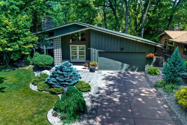 3914 Priscilla Ln, Madison, WI 53705 - mid-century home featuring a chimney, a garage, a front yard, and concrete driveway