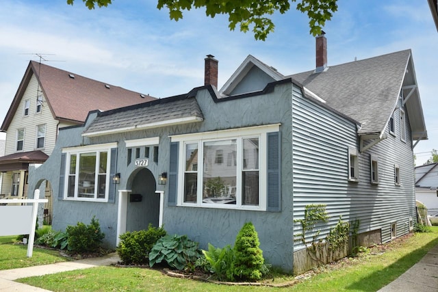 3727 E Layton Ave, Cudahy, WI 53110 - view of front of home featuring a shingled roof, a chimney, and stucco siding