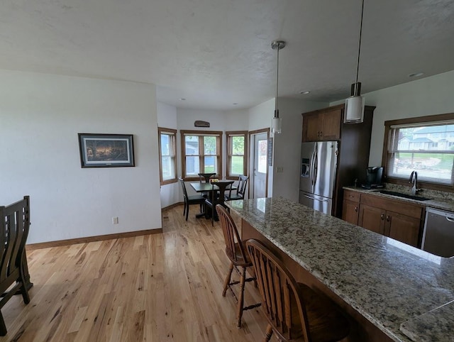 5235 Killdeer Ln, Oshkosh, WI 54901 - kitchen featuring stainless steel appliances, a sink, a breakfast bar, and healthy amount of natural light