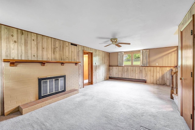 2044 E Vista Cir, De Pere, WI 54115 - unfurnished living room featuring a baseboard radiator, wood walls, a fireplace, ceiling fan, and carpet floors