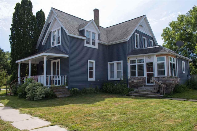 202 Wisconsin St, Mauston, WI 53948 - view of front of house featuring a chimney, a porch, a front yard, and roof with shingles