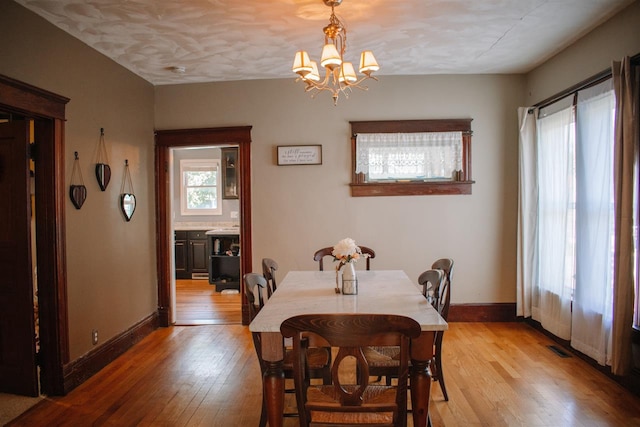 202 Wisconsin St, Mauston, WI 53948 - dining space with light wood finished floors, a chandelier, and baseboards