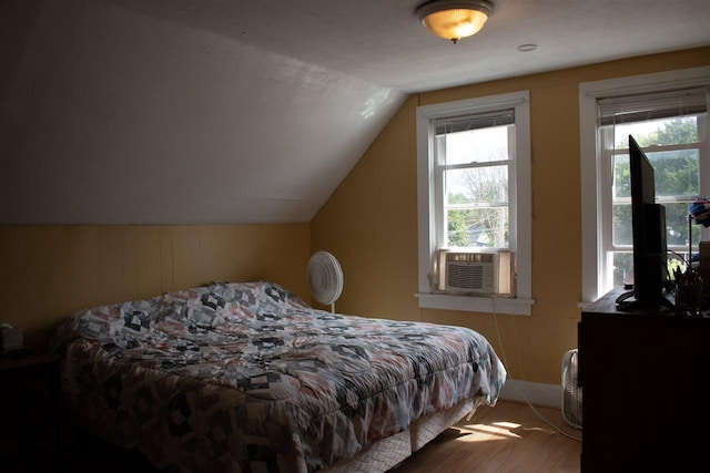202 Wisconsin St, Mauston, WI 53948 - bedroom featuring cooling unit, multiple windows, lofted ceiling, wood finished floors, and baseboards