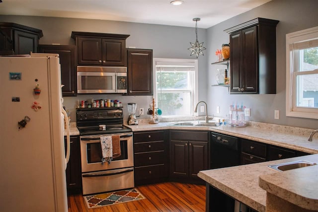202 Wisconsin St, Mauston, WI 53948 - kitchen with appliances with stainless steel finishes, a sink, dark wood-style floors, light countertops, and recessed lighting