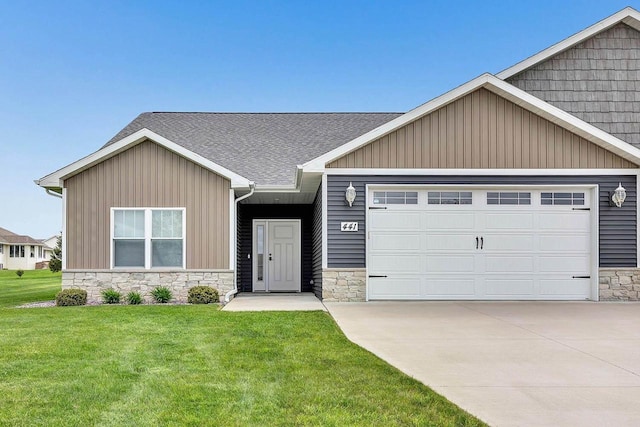 441 Longwood Ln, Wrightstown, WI 54180 - view of front of home featuring stone siding, a garage, a front lawn, concrete driveway, and a shingled roof