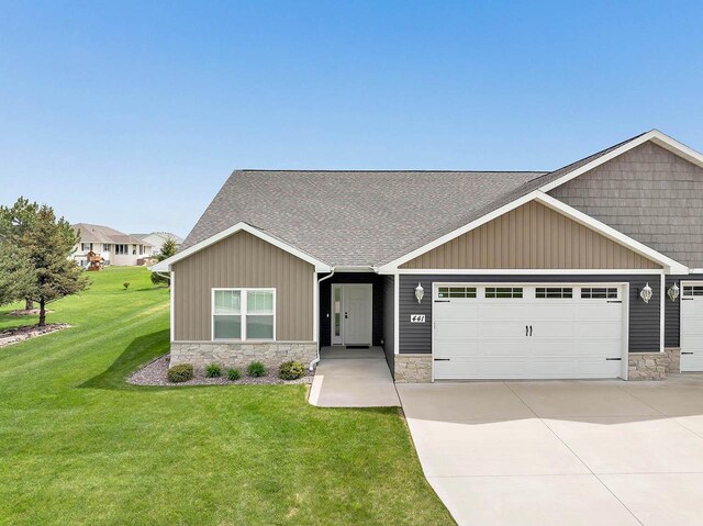 441 Longwood Ln, Wrightstown, WI 54180 - craftsman-style house with stone siding, an attached garage, a front yard, and concrete driveway
