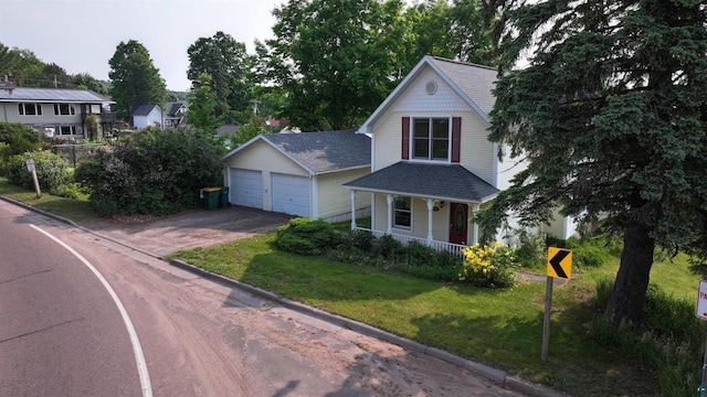240 6th St S, Bayfield, WI 54814 - victorian house with covered porch, a front lawn, a detached garage, and a shingled roof