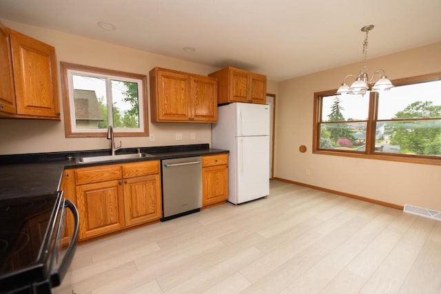 217 E Division St, Dodgeville, WI 53533 - kitchen with freestanding refrigerator, dishwasher, a sink, a chandelier, and healthy amount of natural light