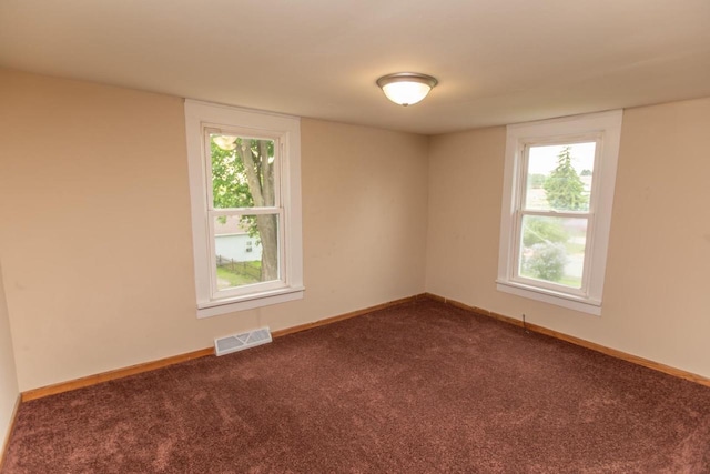 217 E Division St, Dodgeville, WI 53533 - spare room with dark carpet, baseboards, and healthy amount of natural light
