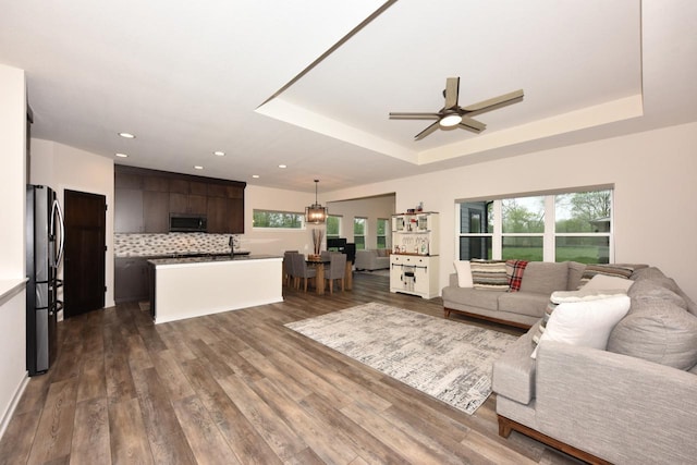 W143N11325 Wrenwood Dr, Germantown, WI 53022 - living room featuring a tray ceiling, ceiling fan, dark wood finished floors, and recessed lighting