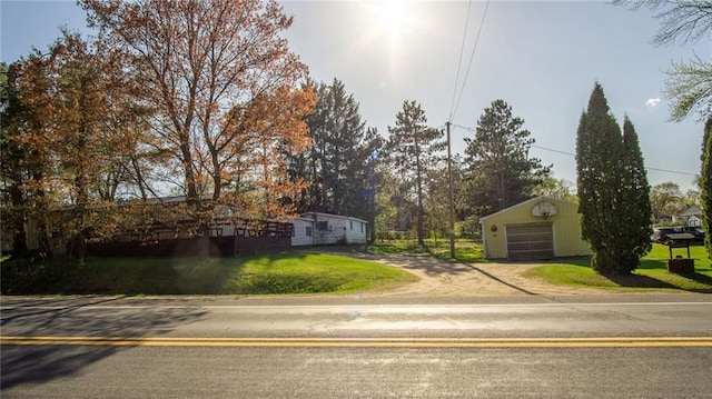 207 State Rd 25, Wheeler, WI 54772 - view of front facade with a garage, driveway, an outdoor structure, and a front yard