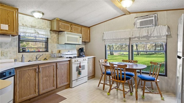 207 State Rd 25, Wheeler, WI 54772 - kitchen featuring white appliances, lofted ceiling, light flooring, light countertops, and brown cabinets