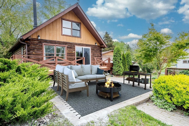 11934 187th Ave, Bristol, WI 53104 - back of property featuring log exterior, an outdoor living space with a fire pit, and a patio
