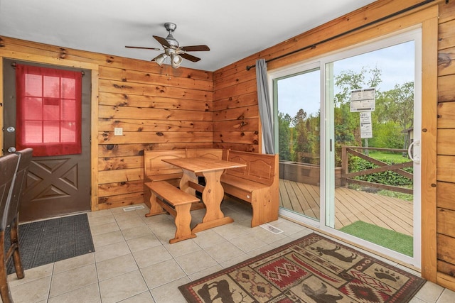 11934 187th Ave, Bristol, WI 53104 - dining space with ceiling fan, light tile patterned floors, and wooden walls