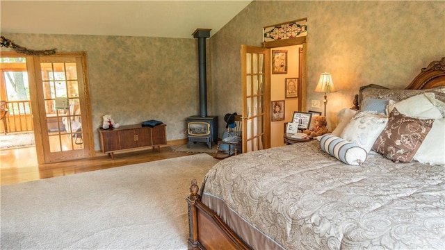 S523 Cole Rd, Mondovi, WI 54755 - bedroom with french doors, carpet floors, a wood stove, and wood finished floors