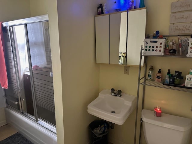 533 High Ave, Oshkosh, WI 54901 - bathroom featuring toilet, a sink, and combined bath / shower with glass door