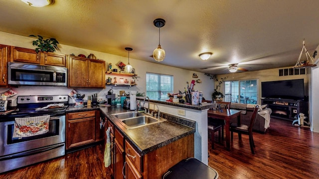 619 Reena Ave Unit 8, Fort Atkinson, WI 53538 - kitchen featuring stainless steel appliances, a sink, dark countertops, dark wood-type flooring, and a peninsula