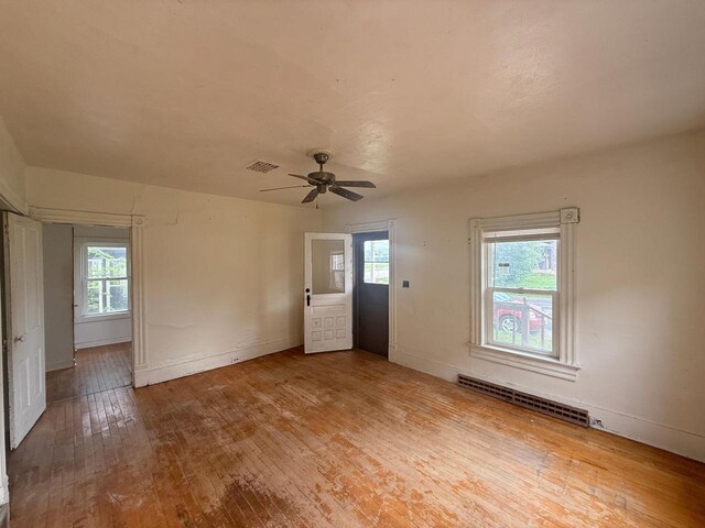 312 W 4th St, Marshfield, WI 54449 - unfurnished living room featuring hardwood / wood-style floors, plenty of natural light, a ceiling fan, and baseboards