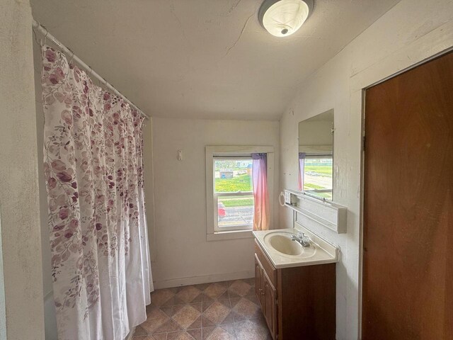312 W 4th St, Marshfield, WI 54449 - full bath featuring vanity, baseboards, a shower with curtain, tile patterned floors, and lofted ceiling