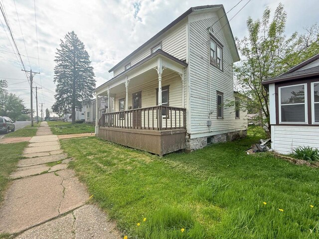 312 W 4th St, Marshfield, WI 54449 - view of side of home with a porch and a yard