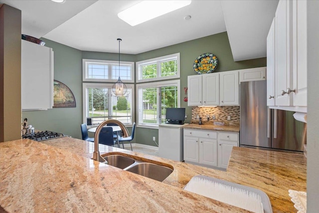 1814 Masters Ln, Madison, WI 53719 - kitchen with a sink, stainless steel appliances, white cabinets, decorative light fixtures, and light stone counters