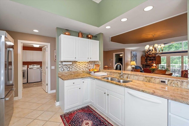 1814 Masters Ln, Madison, WI 53719 - kitchen with a sink, washing machine and dryer, freestanding refrigerator, white dishwasher, and recessed lighting
