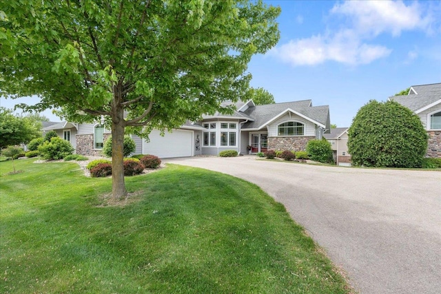 1814 Masters Ln, Madison, WI 53719 - view of front of house with stone siding, asphalt driveway, an attached garage, and a front yard