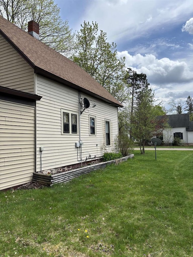 307 E Washington St, Crandon, WI 54520 - rear view of property featuring a lawn, a chimney, and roof with shingles