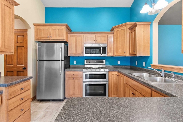 1126 Princess Dove Cir, De Pere, WI 54115 - kitchen with appliances with stainless steel finishes, a sink, arched walkways, and dark countertops