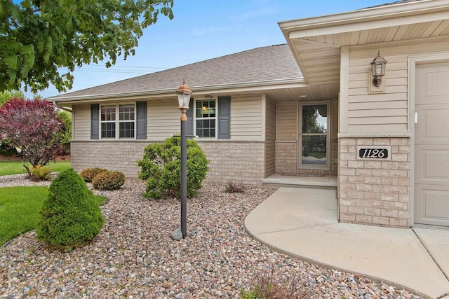 1126 Princess Dove Cir, De Pere, WI 54115 - doorway to property featuring brick siding, a shingled roof, and a garage
