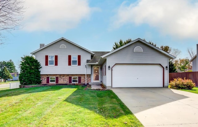182 Ames St, Oregon, WI 53575 - split level home with a garage, concrete driveway, a chimney, and brick siding