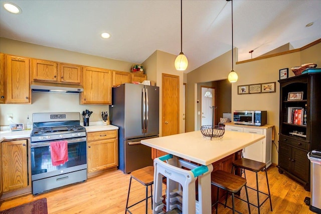 182 Ames St, Oregon, WI 53575 - kitchen with appliances with stainless steel finishes, under cabinet range hood, light countertops, light wood-style flooring, and a kitchen breakfast bar