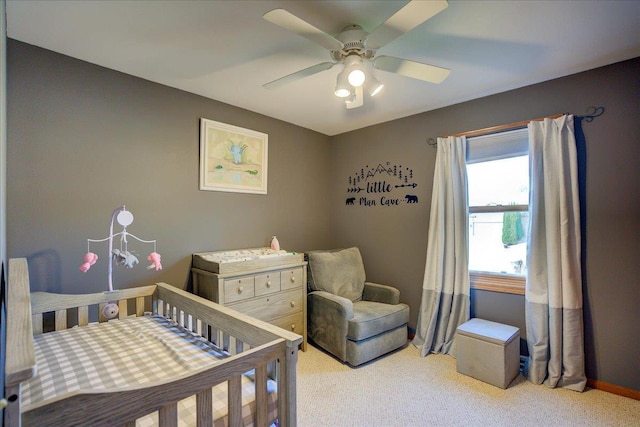 182 Ames St, Oregon, WI 53575 - carpeted bedroom featuring a crib, ceiling fan, and baseboards