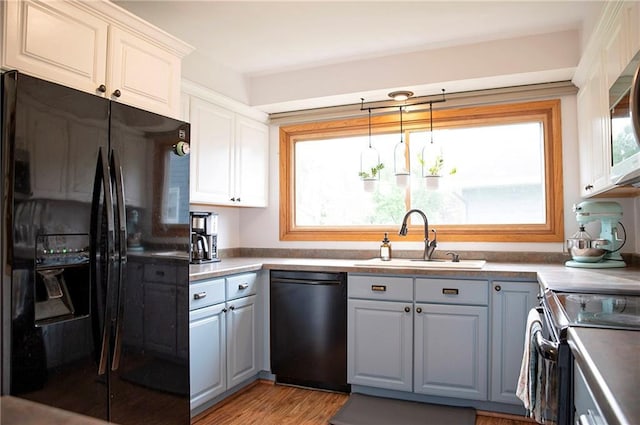 2702 Clark Pl, Eau Claire, WI 54701 - kitchen with black appliances, a sink, gray cabinets, light wood-style floors, and decorative light fixtures