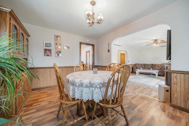 W8749 Hunters Rd, Hortonville, WI 54944 - dining space featuring arched walkways, light wood-style floors, a wainscoted wall, a chandelier, and wooden walls