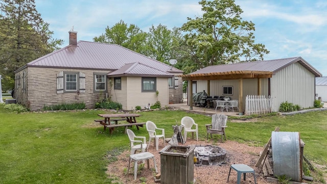 W8749 Hunters Rd, Hortonville, WI 54944 - back of house featuring a fire pit, a chimney, a yard, a patio, and metal roof