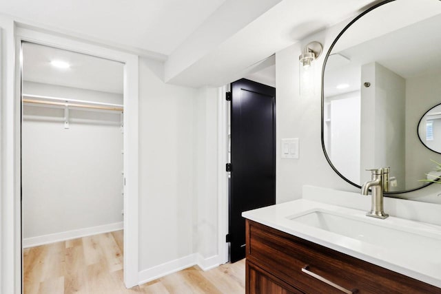 6020 Briarclift Ct, Greendale, WI 53129 - bathroom with wood finished floors, vanity, a walk in closet, and baseboards