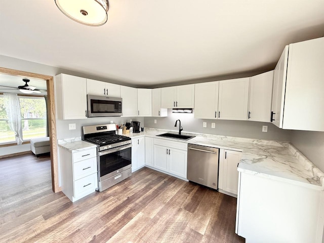 519 Rogers St, Milton, WI 53563 - kitchen with appliances with stainless steel finishes, a sink, light wood-type flooring, white cabinets, and light stone countertops