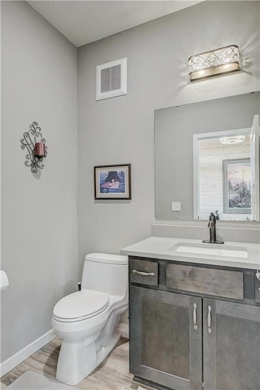 17690 Clayton Ave, Rosemount, MN 55068 - half bathroom with baseboards, toilet, wood finished floors, and vanity