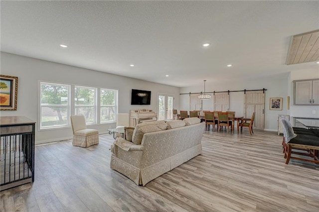 17690 Clayton Ave, Rosemount, MN 55068 - living area with light wood-type flooring, a barn door, recessed lighting, and baseboards