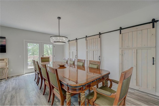 17690 Clayton Ave, Rosemount, MN 55068 - dining space with a barn door, light wood-style floors, a chandelier, and baseboards