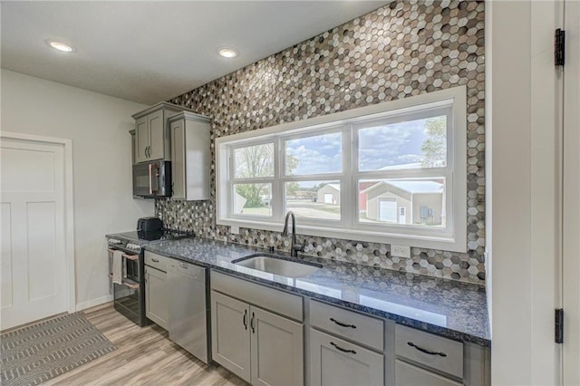 17690 Clayton Ave, Rosemount, MN 55068 - kitchen with stainless steel appliances, a sink, gray cabinets, decorative backsplash, and dark stone countertops